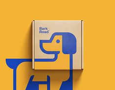 a box with a dog on it sitting next to a yellow and blue sign that says bark road