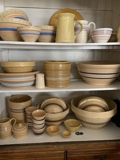 the shelves are filled with dishes and bowls