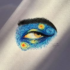 an eye with blue and yellow swirls painted on it's irise area