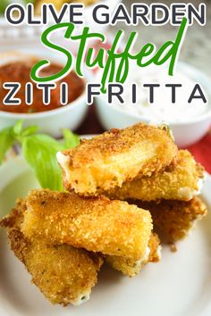 some fried food on a white plate with sauces in the background and text overlay that reads olive garden stuffed zucchini fritta