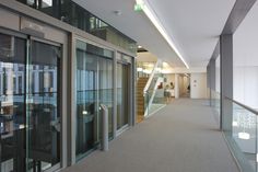 an empty hallway with glass doors and stairs