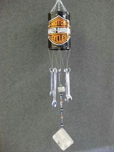 a motorcycle themed wind chime hanging from the ceiling in front of a gray wall