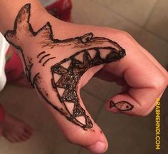 a person's hand with a drawing of a shark on it