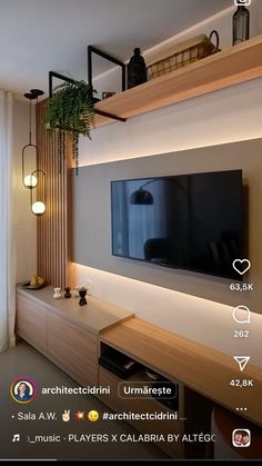 a flat screen tv mounted to the side of a wall next to a wooden shelf