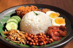 a plate with rice, beans, cucumbers and eggs