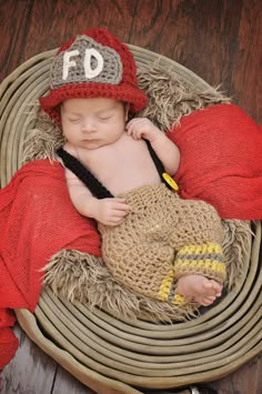 a newborn baby is wearing a fireman hat