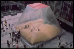 an inflatable piece of bread is on the ground with people walking around it