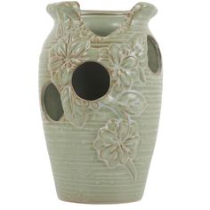 a ceramic vase with flowers and leaves on the bottom is shown in light green color