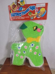 a green dog shaped cake sitting on top of a wooden table next to a package of frosting