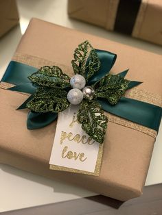 a present wrapped in brown paper with a green ribbon and bow on top of it