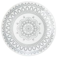 a white and grey plate with an intricate design on the front, sitting on a white surface