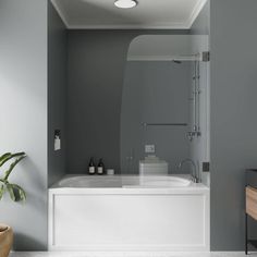 a white bath tub sitting next to a wooden cabinet in a bathroom with gray walls