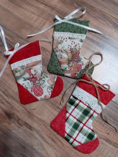 three christmas stocking ornaments on a wooden floor