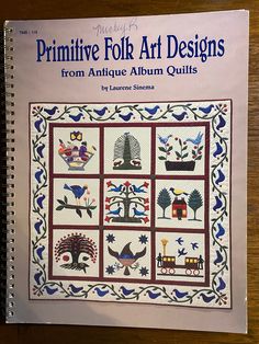 the book primitive folk art designs from antique album quilts is displayed on a table