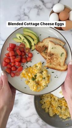 someone is holding a plate with eggs, toast and vegetables