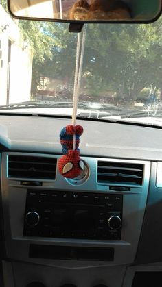 a car dashboard with a stuffed animal hanging from the dash board