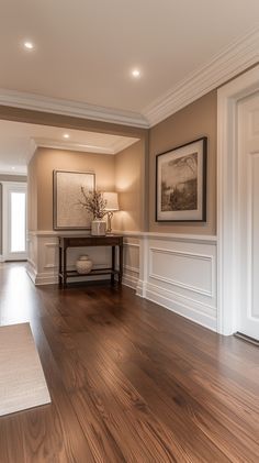 an empty living room with hard wood floors and white trim on the walls is shown