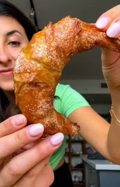 a woman holding up a piece of food in her hands