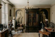 an old fashioned room with antique furniture and paintings on the walls