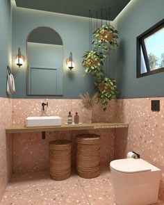 a bathroom with blue walls and pink flooring, two round wicker baskets under the sink