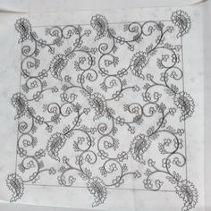 a piece of paper that has been embroidered onto it with vines and leaves on it