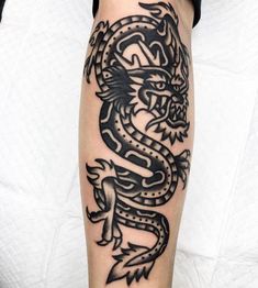 a black and white tattoo design of a dragon on the right leg, done by person