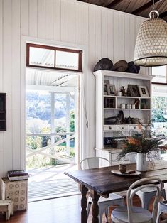 a dining room table and chairs in front of an open window