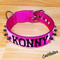 a pink dog collar with black spikes and the word konny on it's side