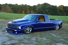 a blue pick up truck parked in a field