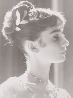 a black and white photo of a woman with her hair in a bun