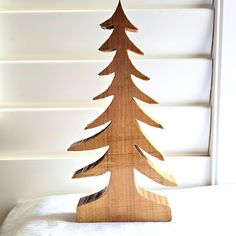 a wooden christmas tree sitting on top of a bed