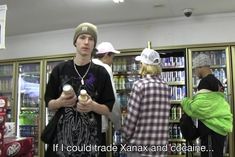 three young men standing in front of a book shelf