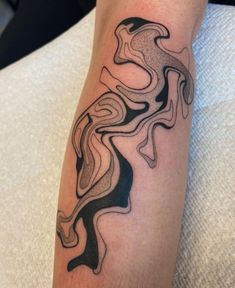 a man's arm with a black and white tattoo design on the left forearm