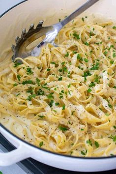 a pot filled with pasta and parsley on top of a stove