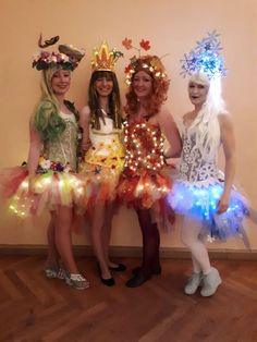 three women dressed in costumes standing next to each other with lights on their heads and hair