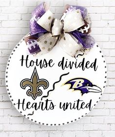 a sign that says house divided hearts united with a baltimore ravens bow hanging on the side of a brick wall