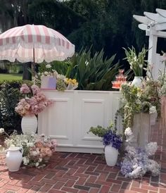 an outdoor bar is decorated with flowers and umbrellas