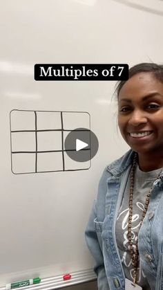 a woman standing in front of a whiteboard with multiple squares on it and the words multiplies of 7