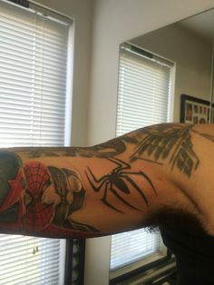 a man with a spiderman tattoo on his arm