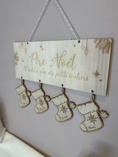 a wooden sign hanging from the side of a wall with christmas stockings and snowflakes