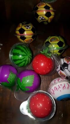 several plastic bowls with painted balls and vegetables in them