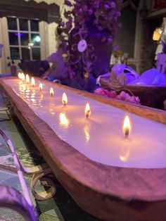 several lit candles are sitting on a long table