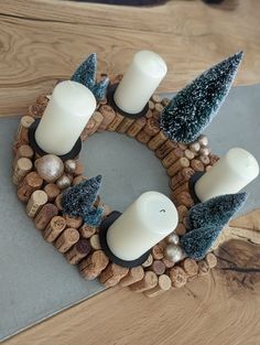 a candle holder made out of wine corks with candles in it and christmas decorations on top