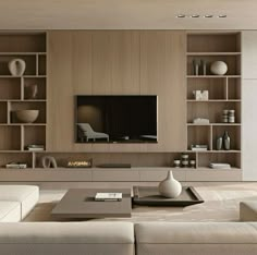 a living room with white couches and wooden shelves