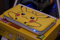 a yellow box with a pikachu design on it sitting next to a game controller