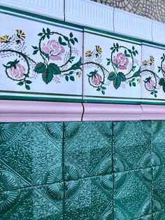 green and white tiles with pink flowers on them