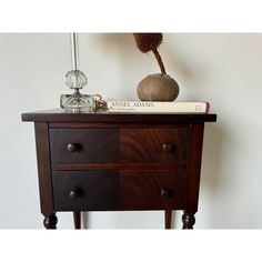 a wooden table with two drawers and a vase on top