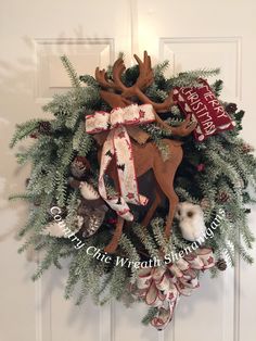 a christmas wreath with deer, pine cones and stockings hanging on the front door to welcome guests