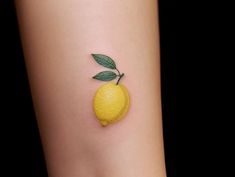 a small yellow lemon tattoo on the ankle