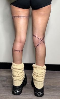 the legs and ankles of a woman with barbed wire on her leg, wearing black high heels